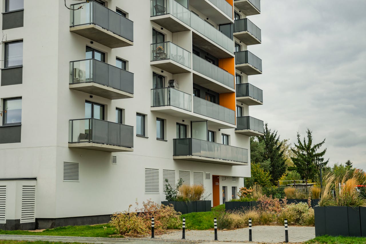 services-04 Contemporary apartment complex featuring glass balconies and landscaped surroundings.